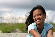 Young Asian Woman Sitting, Smiling on Beach